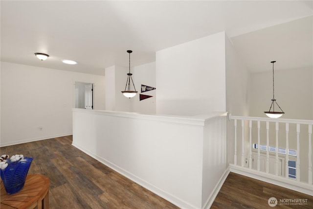 interior space featuring decorative light fixtures, baseboards, and wood finished floors