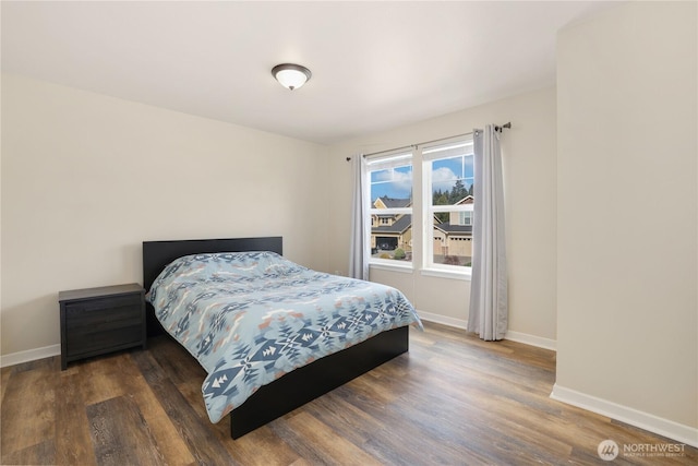 bedroom with baseboards and wood finished floors