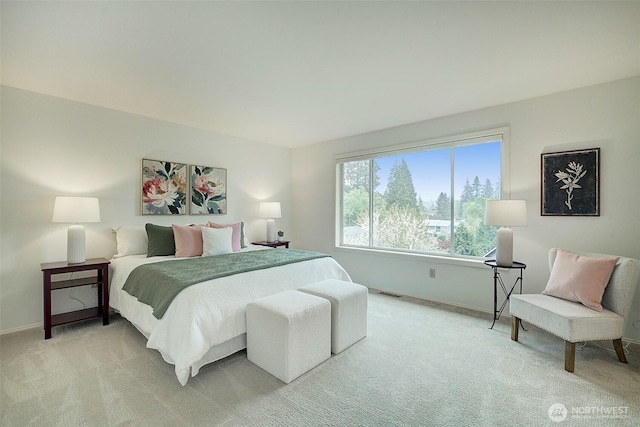 bedroom with baseboards, light carpet, and visible vents