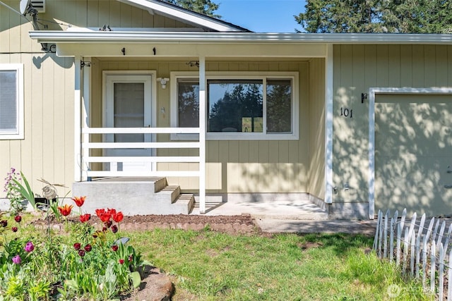 entrance to property featuring a porch and fence
