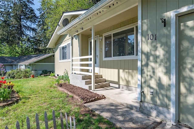 entrance to property with a lawn