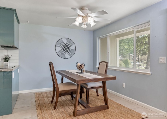 dining area featuring light tile patterned floors, ceiling fan, and baseboards