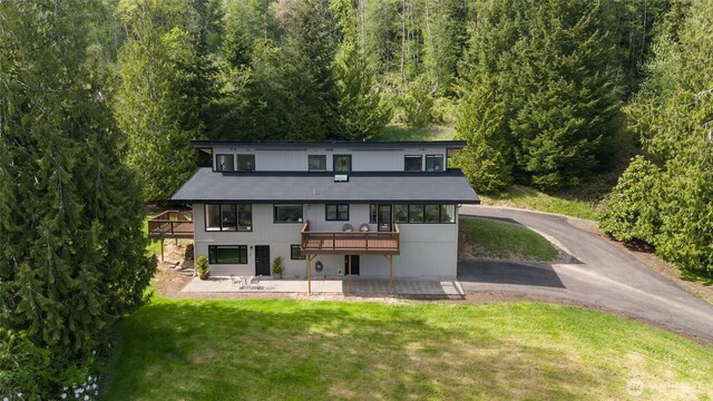 3837 Columbia Heights Rd, Longview, WA 98632 - back of property featuring a lawn, a forest view, a wooden deck, and a patio area