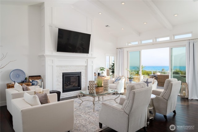 33 E Seashore Ln, Sequim, WA 98382 - living room with high vaulted ceiling, beamed ceiling, a stone fireplace, and dark wood-style floors