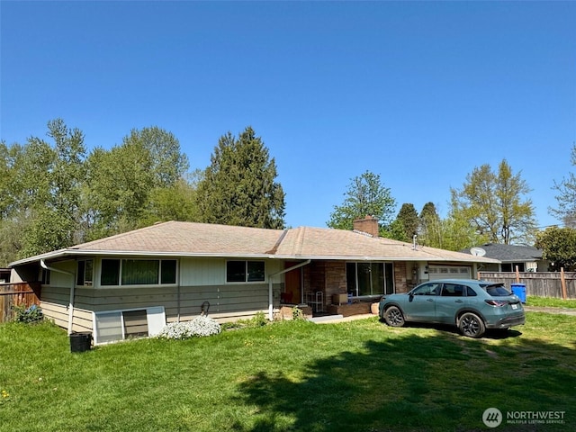 ranch-style home with fence, a chimney, and a front yard