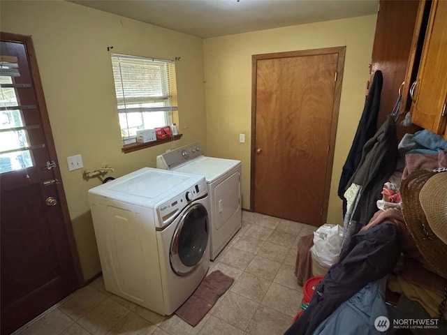 clothes washing area featuring separate washer and dryer, light tile patterned floors, laundry area, and plenty of natural light