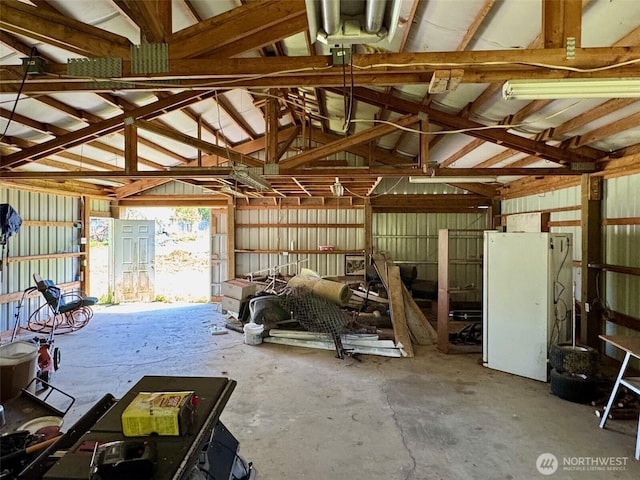 misc room with concrete floors, vaulted ceiling, and a garage