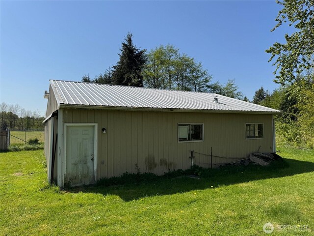 view of property exterior with a lawn and metal roof