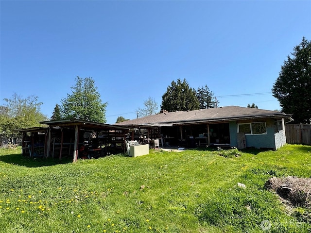 rear view of house featuring a yard