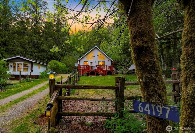 64197 E Cascade Dr, Marblemount, WA 98267 - gate at dusk featuring fence, a wooden deck, and a lawn
