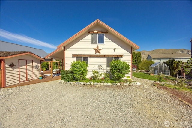 view of front of property featuring an outbuilding and a greenhouse