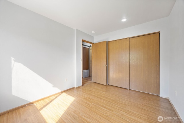 unfurnished bedroom featuring recessed lighting, a closet, light wood finished floors, and baseboards