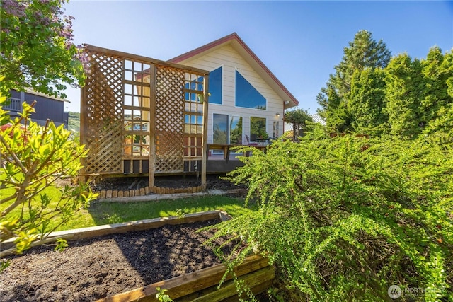 rear view of house with a garden and a deck