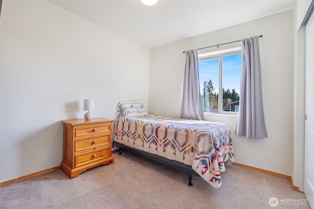 bedroom featuring baseboards and light colored carpet