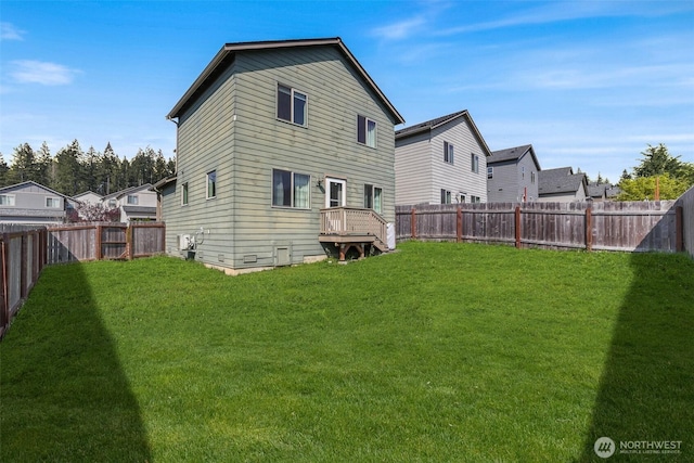 back of property with a lawn, a residential view, and a fenced backyard