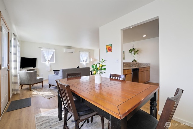 dining space with an AC wall unit and light wood-type flooring