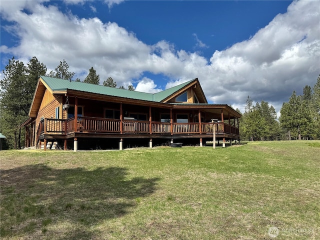 rear view of property with metal roof and a lawn