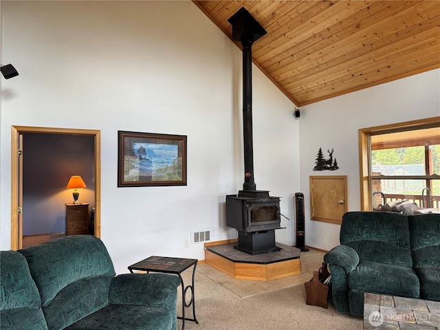 living area featuring wooden ceiling, carpet floors, visible vents, a wood stove, and high vaulted ceiling