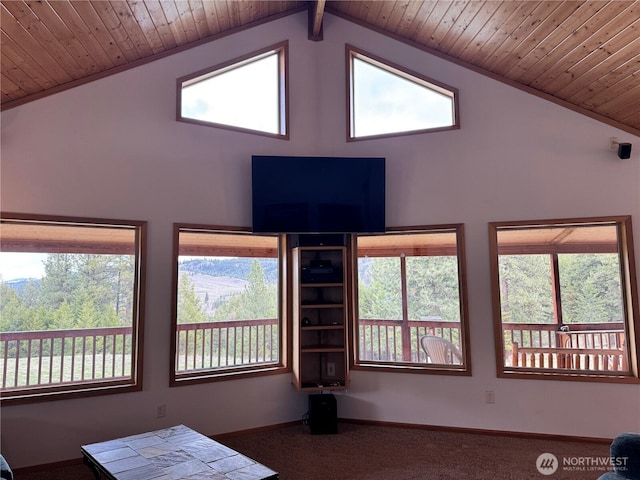 carpeted living area featuring plenty of natural light, high vaulted ceiling, baseboards, and wood ceiling