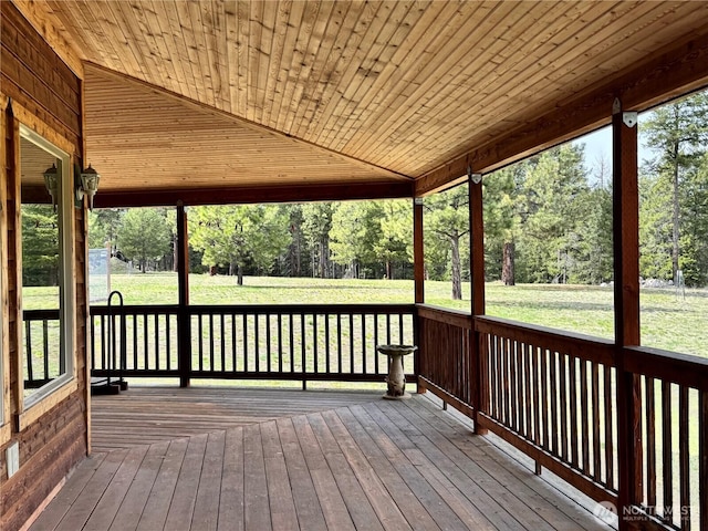 wooden deck featuring a lawn