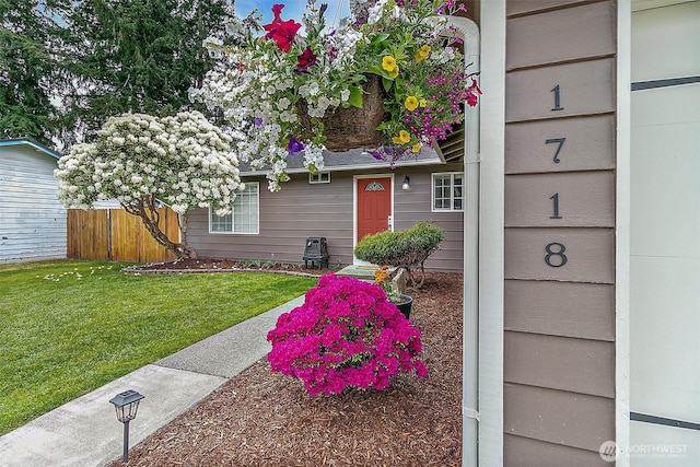 entrance to property with fence and a yard
