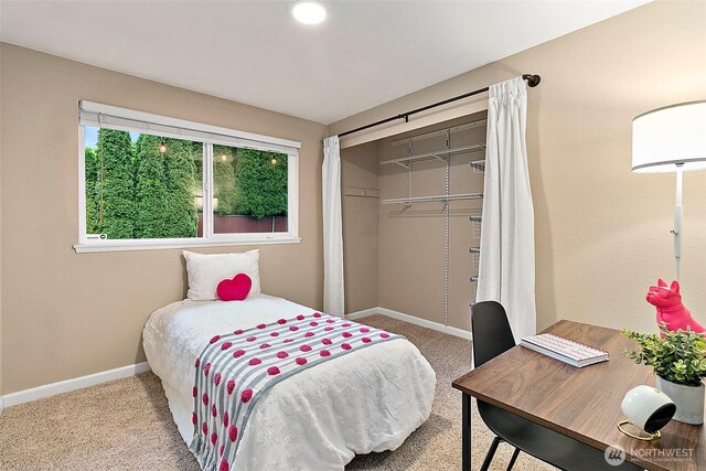 bedroom with baseboards, carpet, and a closet