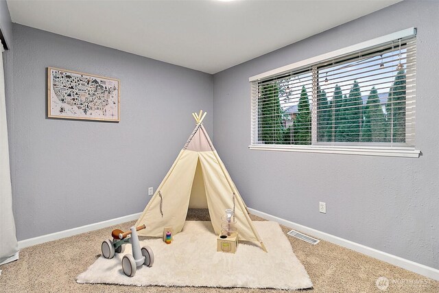 rec room with carpet floors, baseboards, and visible vents