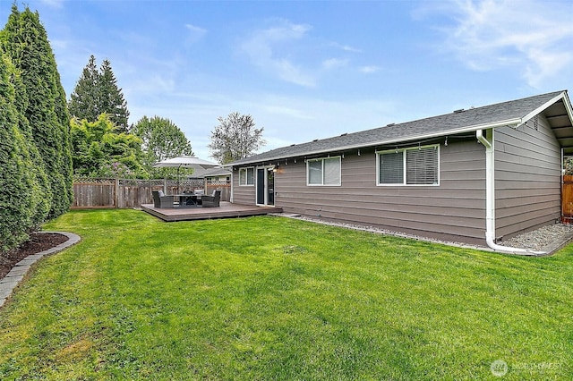 back of house featuring fence private yard, a lawn, and a wooden deck