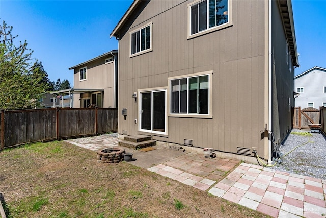 back of house with a patio, crawl space, a fire pit, and a fenced backyard