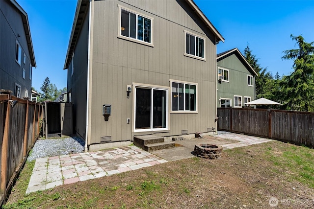 back of property featuring a patio, a fenced backyard, and an outdoor fire pit