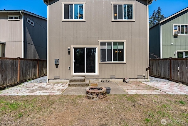 rear view of house featuring a patio area, crawl space, an outdoor fire pit, and a fenced backyard