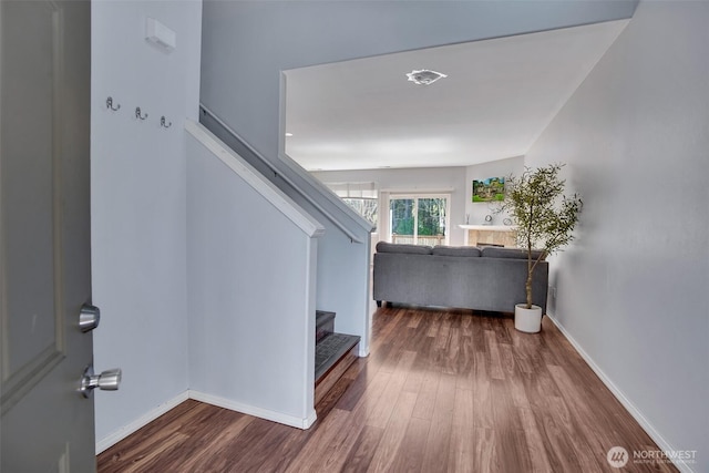 entryway with stairway, wood finished floors, and baseboards