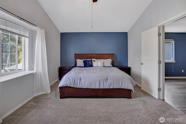 carpeted bedroom with lofted ceiling, a ceiling fan, and baseboards