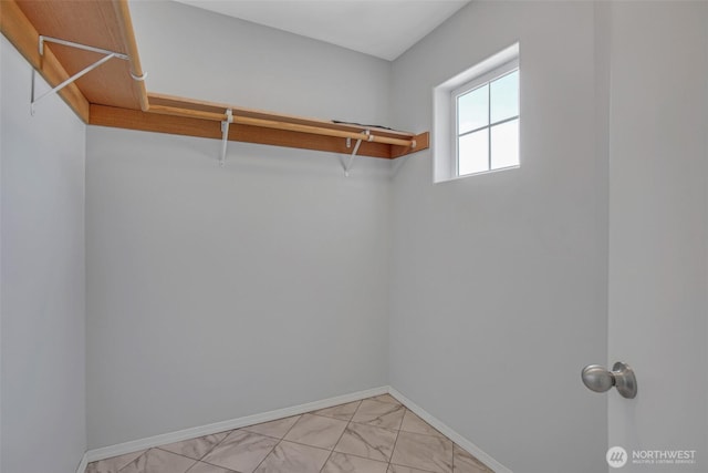 walk in closet with marble finish floor