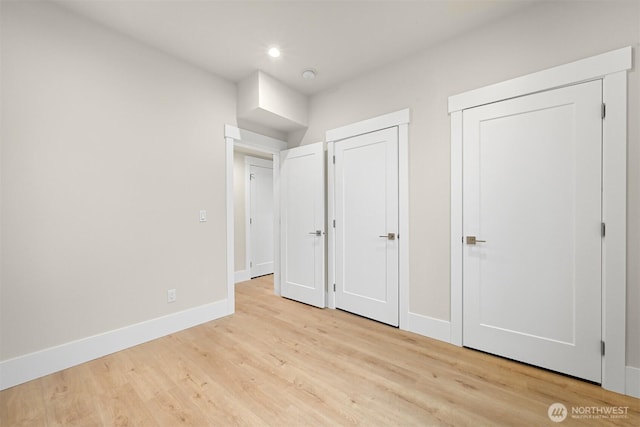 unfurnished bedroom with baseboards, wood finished floors, and recessed lighting