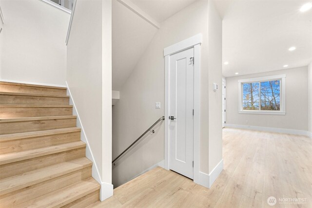stairway with baseboards, wood finished floors, and recessed lighting