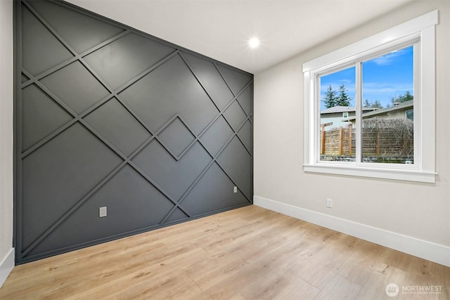 empty room with light wood-style flooring, baseboards, and recessed lighting