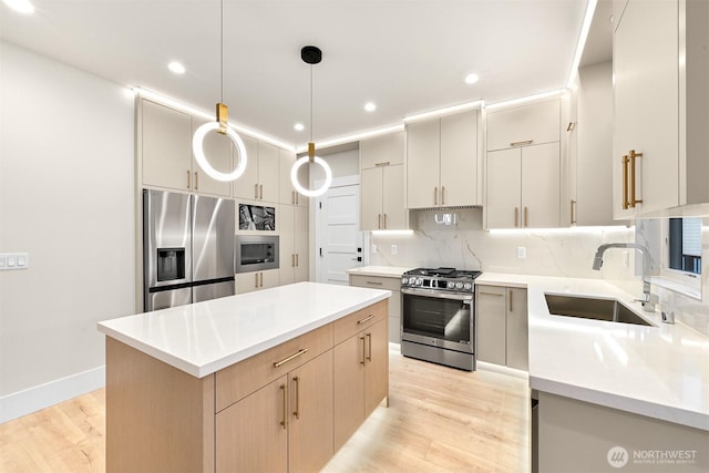 kitchen with light wood finished floors, a sink, backsplash, a kitchen island, and appliances with stainless steel finishes