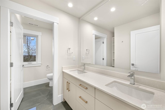 bathroom featuring a sink, toilet, visible vents, baseboards, and recessed lighting