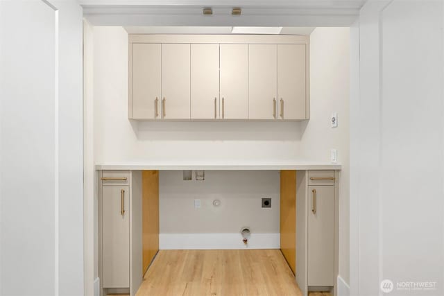 laundry room with hookup for a gas dryer, light wood-style flooring, hookup for an electric dryer, and cabinet space