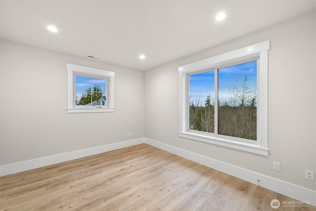 spare room with baseboards, light wood-style flooring, visible vents, and recessed lighting