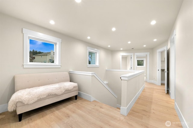 living area with baseboards, an upstairs landing, light wood finished floors, and recessed lighting