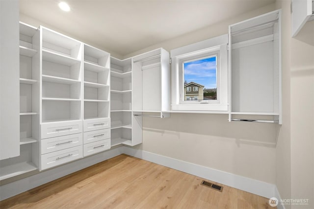spacious closet with light wood-style floors and visible vents