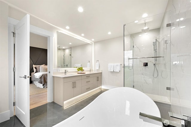 full bath featuring a freestanding bath, a sink, a marble finish shower, and double vanity