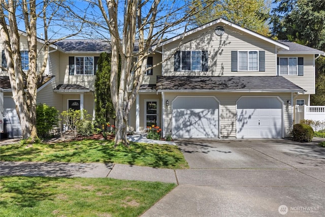 traditional home with a garage, fence, and concrete driveway