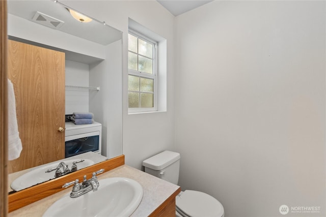 bathroom with toilet, visible vents, and vanity