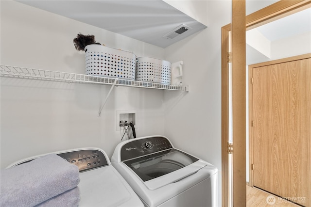 washroom with separate washer and dryer, laundry area, visible vents, and light wood-type flooring