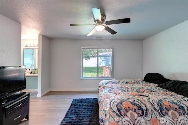 19802 118th Avenue Ct E, Graham, WA 98338 - bedroom with light wood-type flooring, a ceiling fan, a textured ceiling, and ensuite bath