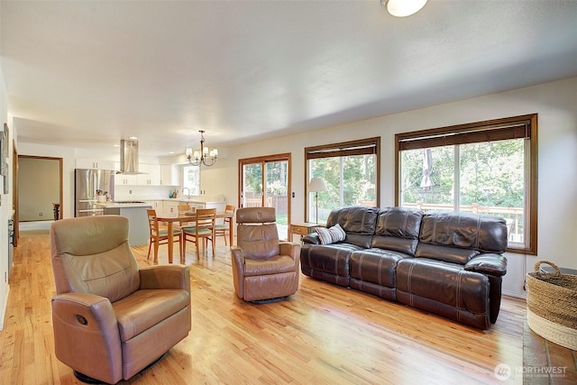 living area featuring light wood-style flooring and a chandelier
