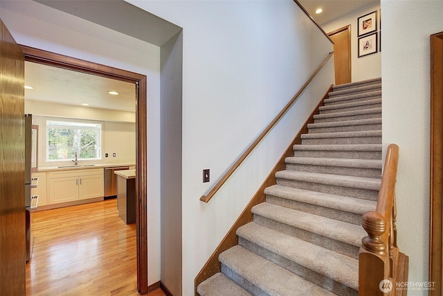 staircase featuring recessed lighting and wood finished floors